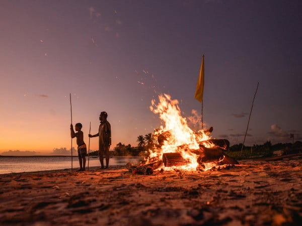 East Arnhem Land aborignal men standing at a fire