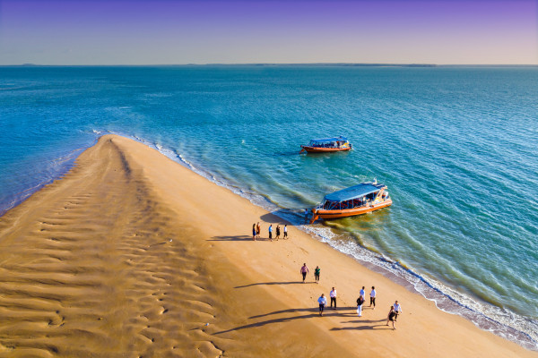 People walking on an ocean sandbar